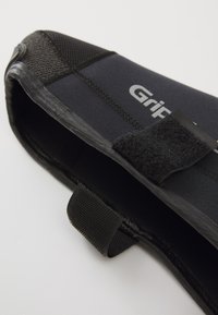 Pantof black din neopren cu vârf întărit, curea cu Velcro și accente texturate. Include branding în argintiu pe lateral.