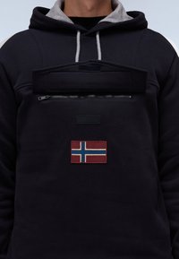 Zwarte hoodie met een grijze kraag, een ritszak aan de voorkant en een rood-blauwe patch van de Noorse vlag op het borstgebied.