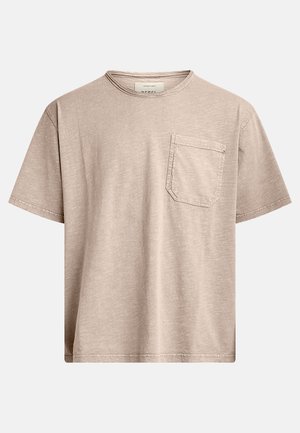 Beige kortærmet t-shirt lavet af blød bomuld med rund hals og en venstre brystlomme med klap. Subtil struktur over det hele.
