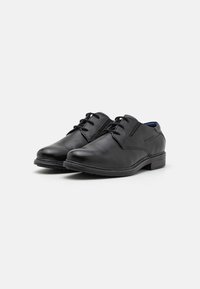 Czarne skórzane buty na elegancką okazję z gładkim wykończeniem, okrągłym noskiem, niskim obcasem i czarnymi sznurowadłami. Charakteryzują się subtelnym przeszyciem i kontrastowym wnętrzem.