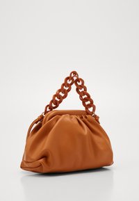 Borsa in pelle marrone con un corpo morbido e arricciato e una maniglia in catena sagomata e grossa. Texture liscia senza motivi visibili o dettagli hardware.