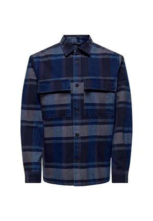Camisa de franela a cuadros en azul marino y gris con botones en la parte frontal, dos bolsillos en el pecho, cuello y mangas largas. Textura suave y corte relajado.
