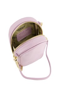 Okrągła jasnoróżowa skórzana torebka crossbody z teksturowaną powierzchnią, złotym zamkiem błyskawicznym i paskiem z akcentami łańcuszka. Wnętrze pokryte markowym wykończeniem.