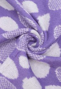 Tessuto viola con pois bianchi, caratterizzato da una consistenza morbida e pelosa. Il materiale è leggero e accogliente, presentando un design a pieghe spiralate.