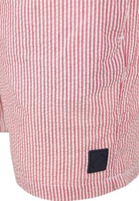 Rood-witte gestreepte shorts gemaakt van lichtgewicht stof, met een gestructureerd oppervlak en een klein zwart logo-opdruk aan de zijkant.