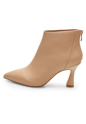 Botín de cuero beige hasta el tobillo con punta afilada y tacón cónico. Presenta una cremallera lateral y una textura suave, ofreciendo un diseño elegante y minimalista.