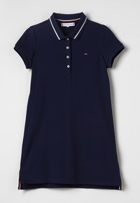 Granatowa sukienka polo z krótkim rękawem, kołnierzykiem, pięcioma guzikami oraz kontrastowymi paskami na kołnierzyku i u dołu.