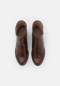 Brown leather ankle boots with a textured crocodile pattern, rounded toe, and side zipper access, featuring a stitched black sole.