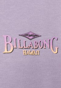 Logo Billabong Hawaii s gradientom ružovej a oranžovej na levanduľovom rebrovanom látkovom pozadí.
