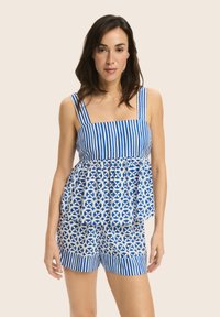 Niebieska i biała paskowana bluzka peplum z szerokimi ramiączkami oraz szortami w kwiatowo-geometryczny wzór. Bawełnowy materiał o luźnym kroju i warstwowej strukturze.