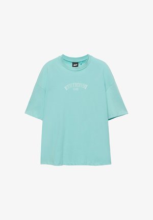 T-shirt oversize bleu clair à manches courtes avec col rond et texte blanc "EDITION 91" imprimé sur la poitrine.