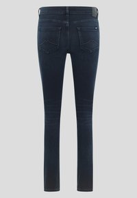 Sötétkék farmer skinny nadrág, sima textúrával, öt zsebbel és Diszkrét kopott hatással a lábakon. A hátsó részen két varrott zseb található.