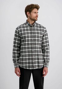 Geruite flanellen overhemd in tinten van grijs, zwart en wit. Heeft een button-down kraag, lange mouwen en een ronde onderkant.