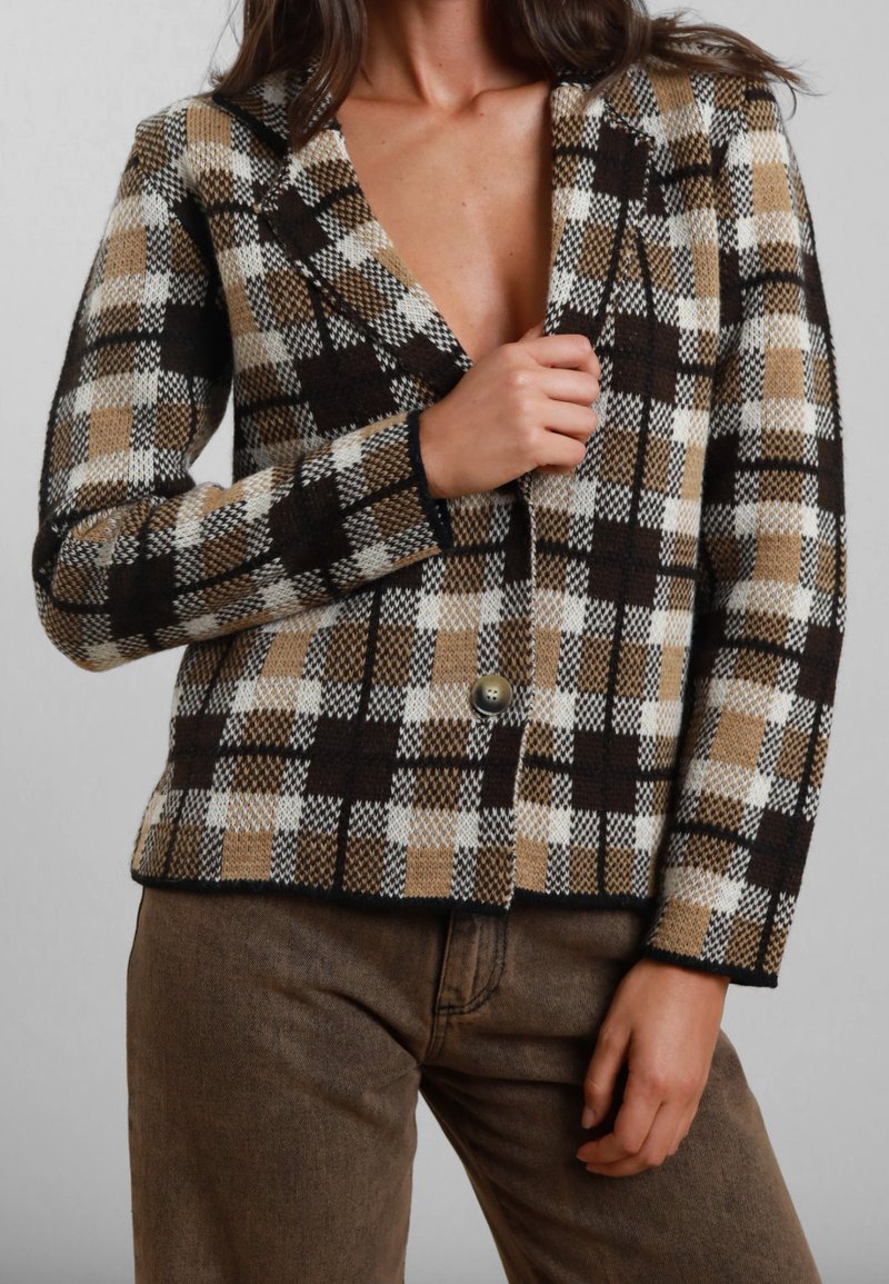 Blazer a scacchi con motivo marrone, beige e bianco; presenta un colletto a scollo a V, chiusura con un solo bottone e tessuto testurizzato.