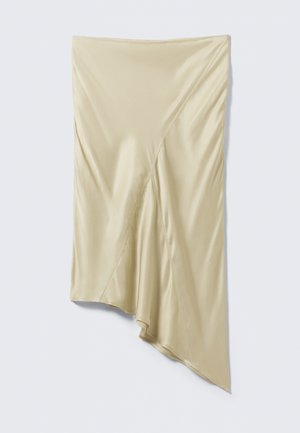 Beige asymmetrisk satin nederdel med diagonale syninger og en draperet, ujævn kant på en lysegrå baggrund.