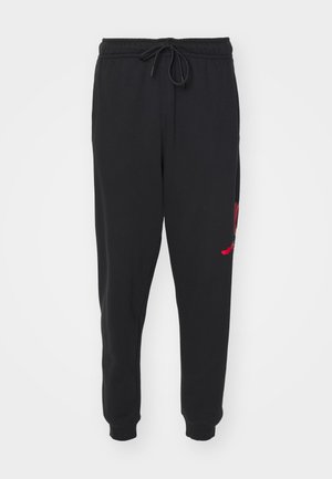 Pantaloni sportivi neri realizzati in tessuto morbido, con vita elastica e cordoncino. La gamba sinistra presenta un dettaglio grafico rosso.