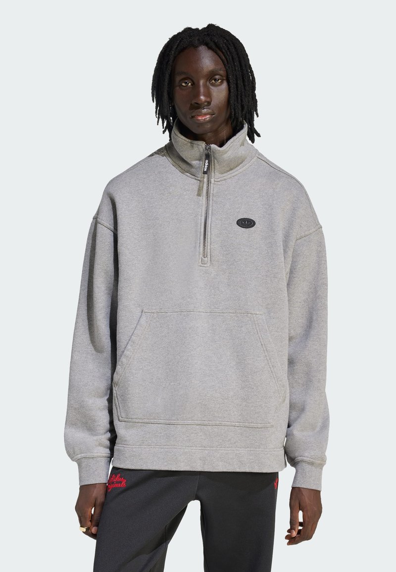 Felpa grigia con zip e collo alto, dotata di tasca frontale e dettaglio logo nero. Tessuto morbido e vestibilità comoda e rilassata per il massimo comfort.