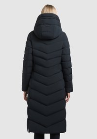 Abrigo largo negro tipo plumas con un patrón de acolchado en forma de chevrón, un cuello alto y una capucha. La tela parece suave y gruesa para proporcionar calor.