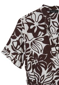 Tunic a manica in tessuto bianco con grandi fantasie floreali marroni, colletto e abbottonatura parziale. Texture morbida di medio peso.