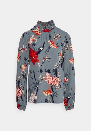 Blaue Langarmbluse mit rotem und pinkem Blumen- und Vogelmuster, hohem Rüschenkragen und elastischen Bündchen.