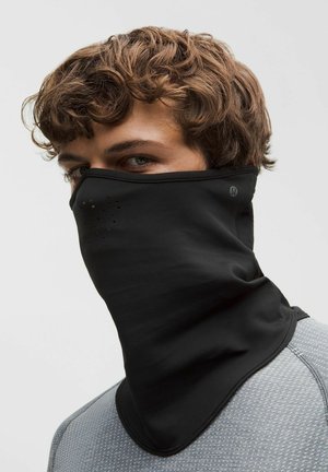 Musta kasvomaski, valmistettu pehmeästä, joustavasta kankaasta, jossa on rei'itetyt yksityiskohdat. Käytetään kaulan ympärillä ja siinä on logo sivulla.