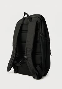 Μαύρο σακίδιο με υφασμάτινη υφή, επενδεδυμένη πλάτη και ρυθμιζόμενους ιμάντες. Διαθέτει διακοσμητικά από δίχτυ και πλαϊνές τσέπες για αποθήκευση.