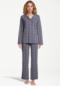 Marinblå pyjamasset med vita prickar, med lång ärm och raka byxor, tillverkat av mjukt tyg, med knäppning framtill.
