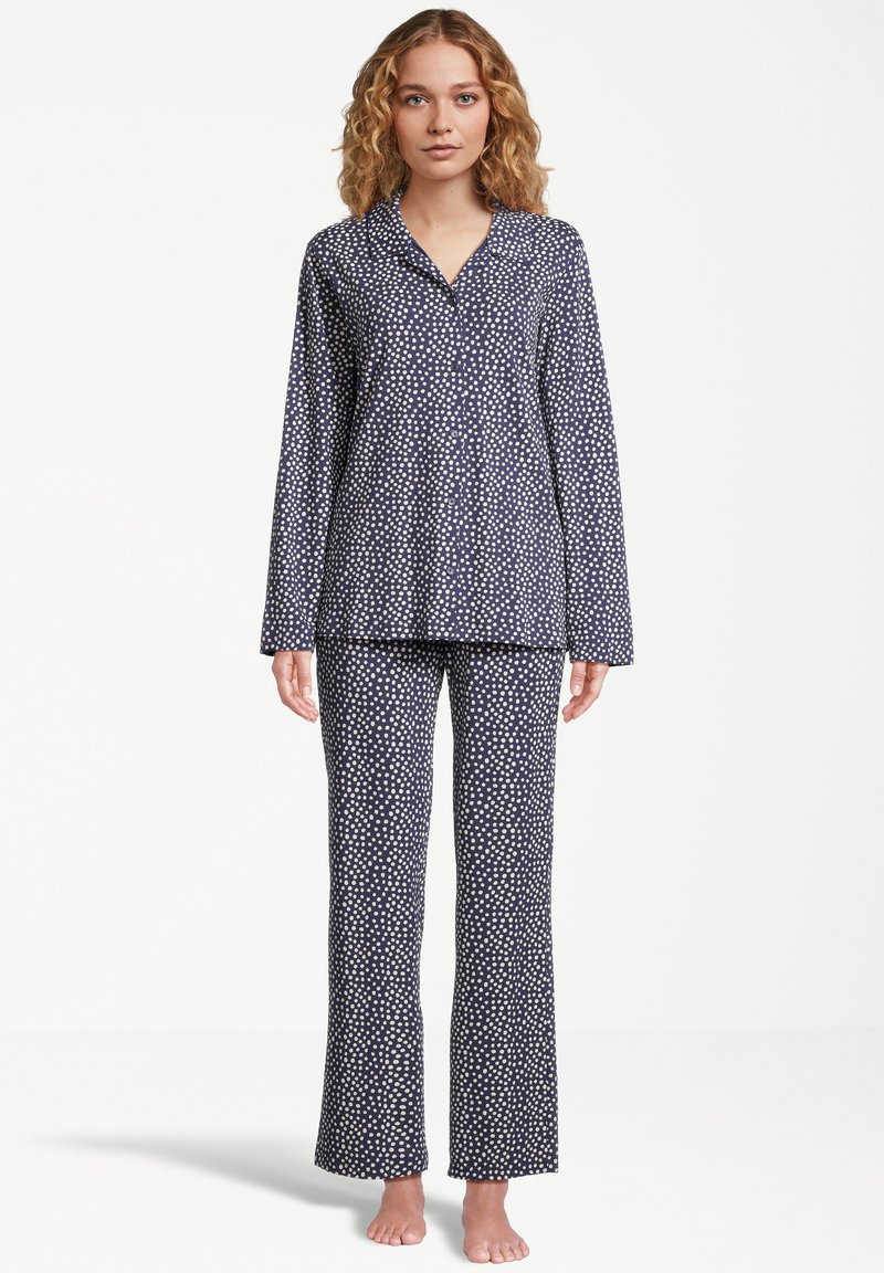 Marinblå pyjamasset med vita prickar, med lång ärm och raka byxor, tillverkat av mjukt tyg, med knäppning framtill.