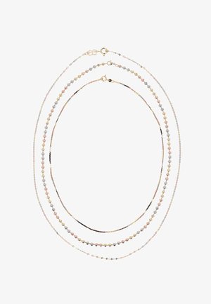 Drie delicate tri-color gouden kettingen met verschillende schakels, gerangschikt in concentrische ovalen op een witte achtergrond.