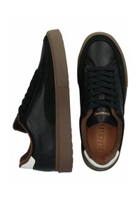 Sneakers neri con tomaia in pelle liscia, dettagli in suede, fodera in soffice marrone e suola in gomma beige chunky. Presentano lacci neri e un logo.