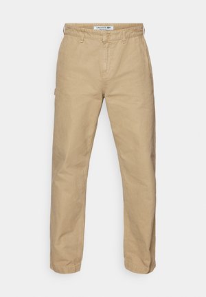 Beige, könnyű pamut nadrág, egyenes szárú kialakítással, gombos zárással és finom textúrával. Lacoste logó a derékrészen.