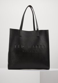 Black tote bag made of textured synthetic material, featuring embossed "TED BAKER LONDON" branding on the front. Two sturdy handles.