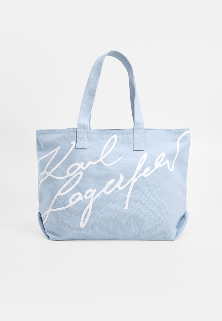 Helle blaue Stofftasche mit zwei Griffen und weißem, großem Schreibschrift-Text auf der Vorderseite.