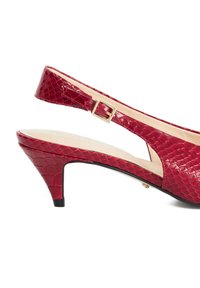 Red patent leather slingback heel with textured crocodile pattern, gold buckle detail, and a tapered heel design.