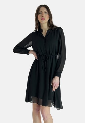 Black, long-sleeve dress made of lightweight fabric, featuring a buttoned front, drawstring waist, and a flowy hem with sheer accents.