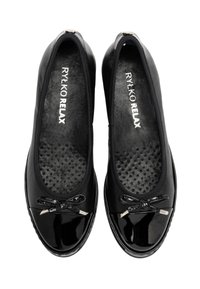 Czarne lakierowane baleriny z okrągłym noskiem, ozdobą w postaci kokardy z przodu oraz perforowanym designem wkładki dla dodatkowego komfortu.