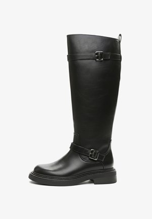 Crna kožna čizma do koljena glatke teksture s detaljima kopči. Ima okrugli vrh i debelu potplat za stabilnost.