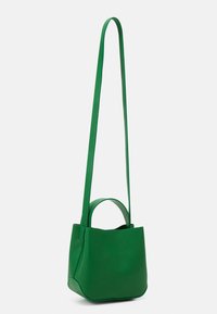 Piccola borsa a tracolla in pelle verde con lunga tracolla e manico corto, esposta su uno sfondo bianco.