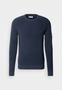 Pull en maille bleu marine avec un motif texturé, col ras du cou et poignets et ourlet côtelés. Présente une étiquette de marque sur la manche gauche.