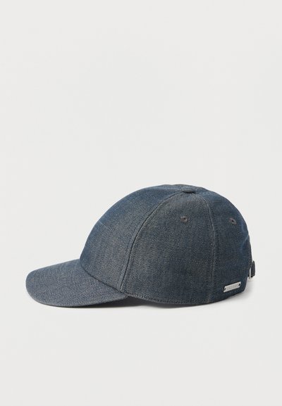 Casquette de baseball en denim bleu foncé avec visière incurvée et sangle réglable sur fond blanc uni.