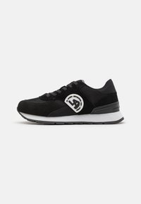 Scarpa sportiva nera con una combinazione di materiali in mesh e suede. Presenta una punta arrotondata, lacci, una suola intermedia bianca e un accento del logo.