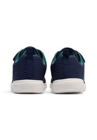 Blå mesh träningsskor med en vit sula, utrustade med en texturerad design och gröna detaljer vid kragen och tungan.