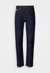 Σκούρο μπλε τζιν παντελόνι με ίσια κοπή στα πόδια, κούμπωμα με πάνω κουμπί, σχεδίαση με πέντε τσέπες, αντιθετικές ραφές και λεία υφή.