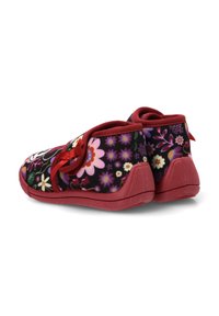 Zapatos rojos con flores sobre un fondo negro, con suela texturizada, cordones de cinta y soporte acolchado para el tobillo.