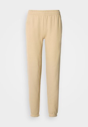 Beige színű pamut tréningnadrág, rugalmas derékkal és cipzáros szegéllyel, sima textúrával és laza szabással.