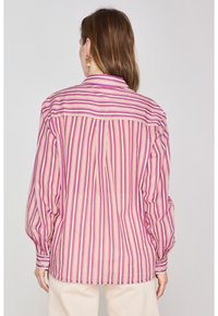 Camicia a righe con linee verticali rosa, crema e gialle. Presenta un polsino con bottoni e un colletto classico. Vestibilità standard con yoke posteriore.