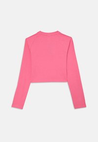 Cropped, long-sleeve top in bright pink ribbed fabric. Features a round neckline and seamless shoulders. Soft texture with stretch.
