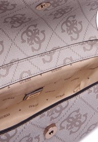 Borsa a mano beige con texture e motivo floreale ripetuto, chiusura a scatto magnetico e una fodera interna liscia con stampa del logo del marchio.
