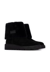 Botas de tobillo negras de ante con una parte superior de piel de pelaje suave, que cuentan con una suela de goma gruesa con un patrón de relieve.