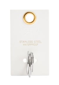 Wodoodporny znacznik ze stali nierdzewnej na białym tle, z złotym metalowym oczkiem i trzema srebrnymi pierścieniami przymocowanymi na dole.